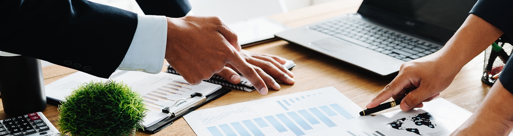 Professionals Pointing At Chart On Desk